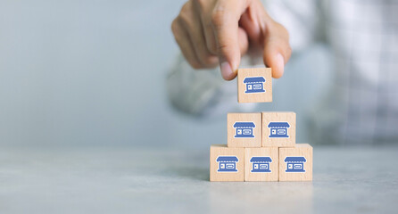 Franchise business,Businessman hand choose wooden blog with franchise marketing icons...