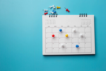 Calendar on solid ิblue background with copy space, pinned in a calender on datebusiness meeting...
