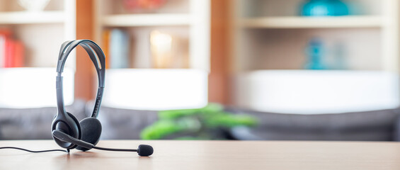 Close up soft focus on headset with telephone devices at office desk for customer service support.VOIP headset for customer service support (call center) concept.