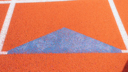 Bright blue relay exchange triangle on orange track.