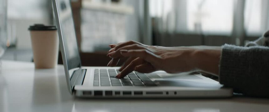 CU hands of Black African American female working from home, using her laptop. Typing and scrolling. Remote work during COVID-19 pandemic