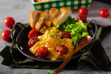 Scrambled eggs with salad and grilled tomatoes