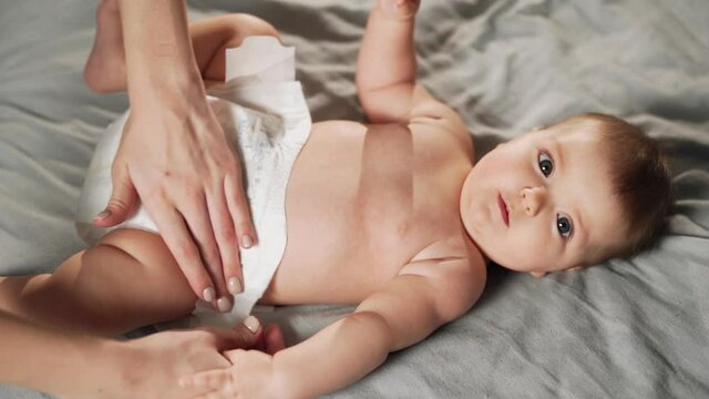 close-up top view of female hands putting on diapers on baby