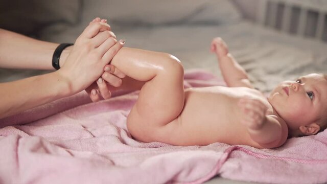 mother's hands rubbing the legs of a cute baby