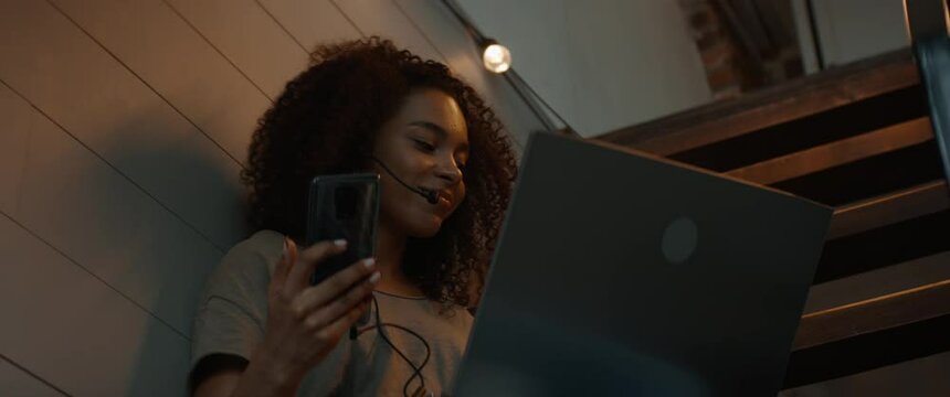 CU Portrait of Black African American female working from home, having a phone call with client or office late in the evening. WFH, stay home, COVID-19 coronavirus pandemic new normal concept