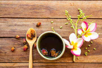 herbal healthy drinks hot tea rose  with flowers frangipani, dried rose arrangement flat lay style on background wooden