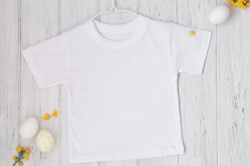 White t-shirt mockup with Easter eggs and hanger, flat lay, top view
