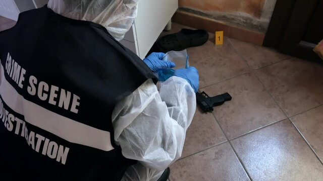 csi investigator at the crime scene who inspects with blue flashlights and takes scientific evidence to take to the laboratory taken from the handle of a house door where a murder was committed