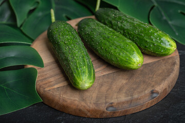 Fresh ripe cucumbers on wooden board