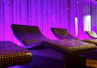Thermal suite with heated loungers in mosaic tile design or relaxation chairs in spa or wellness...