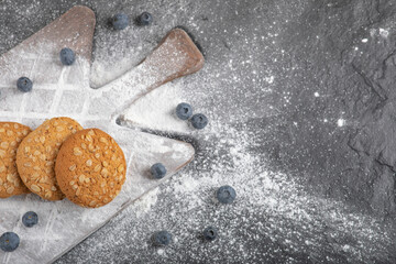 Delicious sweet biscuits on wooden board with blueberries