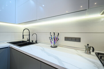 Fototapeta na wymiar Closeup to luxury gray modern kitchen interior