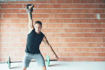Sporty young man doing kettlebell swing exercise - 416898398