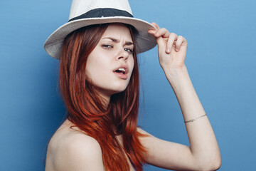 pretty fashionable woman in hat red hair glamor studio blue background