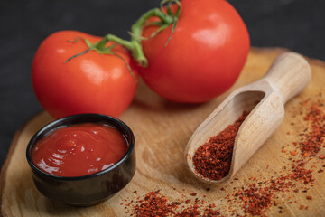 Close up photo of fresh ripe tomatoes with ketchup and pepper on wooden baord