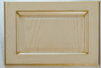 beige kitchen facade close-up. background of yellow wooden decorative item