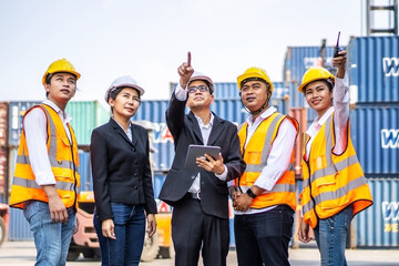 The Asian construction foreman pointed out and discussed new projects for engineers and container workers at the container warehouse. Business Freight Forwarding Logistics Corporate Teamwork Success