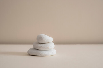 Minimal zen natural beauty. Background for branding and product presentation. Still life mock up photo of white marble stones with long shadow on beige table.