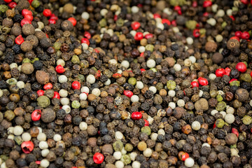 Black, White, Red, and Green Kampot and Madagascar Peppers mixed as Background