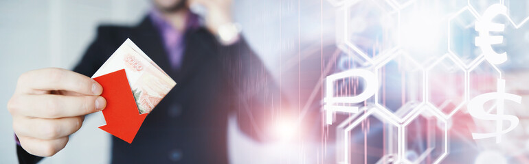 Financial crisis. Concept. Money bills in hand. Arrow symbol of the fall of the national currency. The change in the exchange rate between the Russian ruble and the US dollar.