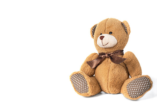 A small teddy bear on a white background with shadows.