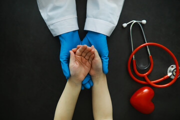 Medical concept. The doctor in gloves holds the patient's hand. The moral help of the doctor to his patients. Cardiologist consultation. Epidemic.