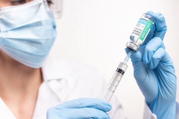 SARS - CoV2 Vaccination concept. Close up COVID-19 vaccine dose. A doctor or nurse in a laboratory holds a vial with a vaccine. Pandemic immunity