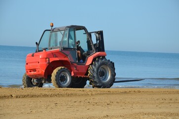 tractor collects seaweed on the beach