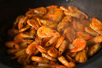 Grilled fresh shrimp, fried with spices and butter. Close-up of fried shrimp in a frying pan