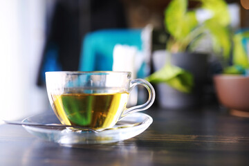 Hot steaming green tea in a cup on a rustic background
