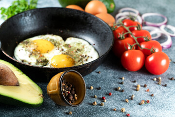 Fried eggs in a frying pan on a gray background.