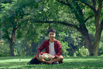 A young man sitting on the lawn at the park