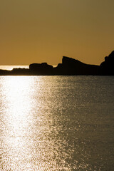 Golden hour abstract seascape with sunlight path on the Black Sea water surface at the fishermen's wharf in Ahtopol, Bulgarian Black Sea Coast