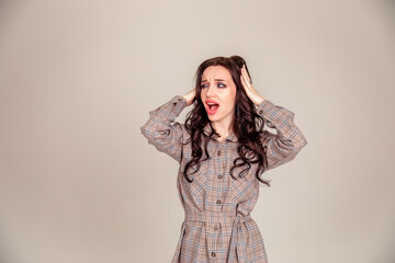 Young woman angry shouts profile. On a gray background.