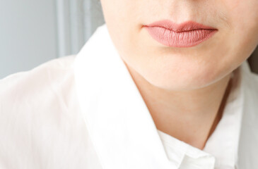 A woman's face with unwanted hair tendrils above the upper lip. problematic facial skin, a problem.