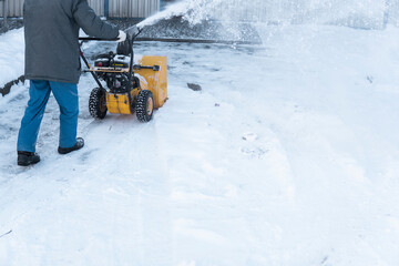 Man cleaning driveway with snow machines after a snow storm. Snow removal equipment working on the...