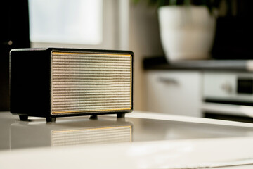 A vintage radio sits on a white table in the kitchen.Stylish music FM wave receiver. Receives the...