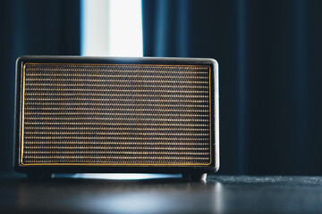 Plays the news channel link. Radio receiver. A modern radio sits on a white table in the kitchen. The music speaker sings a melody.