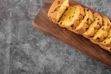 Top view of Sliced homemade roulette cake on wooden chopping board