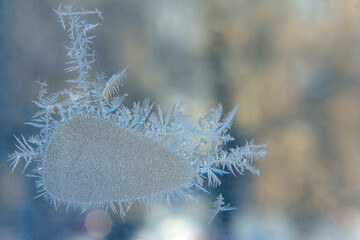 frosty patterns on the window glass closeup. natural textures and backgrounds. ice patterns on...