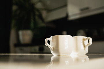 An invigorating drink instead of an energy drink. Two ceramic cups of coffee with a hot aromatic drink. There are two servings of Americano and espresso on the table. Morning light from the window.
