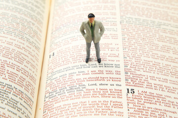 miniature people. man stands on the bible text. search for the path of life. I am the way.