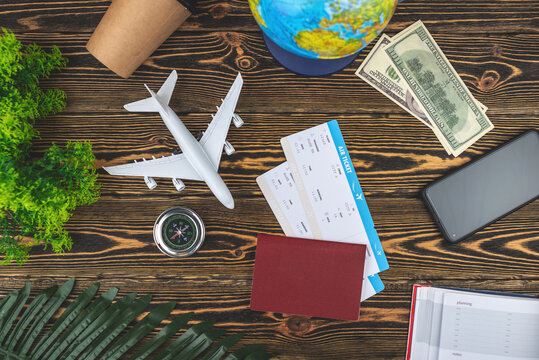 Layout of airplane travel accessories on a wooden background. Top view