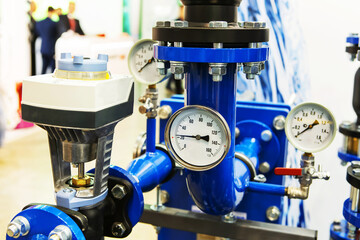 Pump and pressure gauge in the piping system. Industrial boiler room equipment with mechanical...