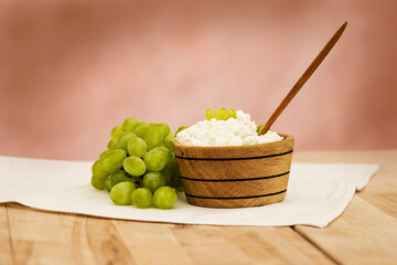  Goat cottage cheese in the wooden bowl  with grape  on a wooden board 