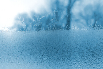 frosty patterns on the window glass closeup. natural textures and backgrounds. ice patterns on...
