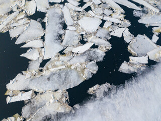 Ice melts on the river. Ice crack. Aerial drone view. Spring sunny morning.