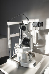 Ophthalmological diagnostic equipment on small table by white wall in clinics