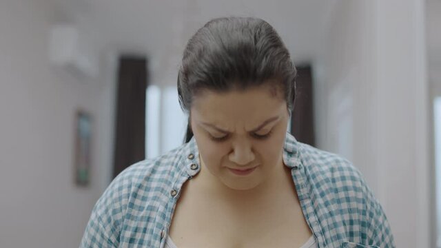 Sad plus size female standing on scales, feeling upset about weight gain, body