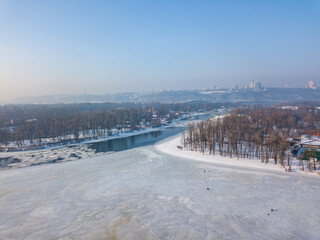 Fototapeta premium Melting Dnieper River in spring Kiev. Ice crack on the river. Aerial drone view. Spring sunny morning.